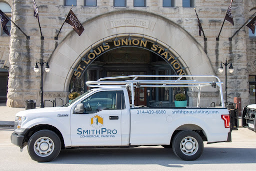 A SmithPro Commercial Painting van in front of a building